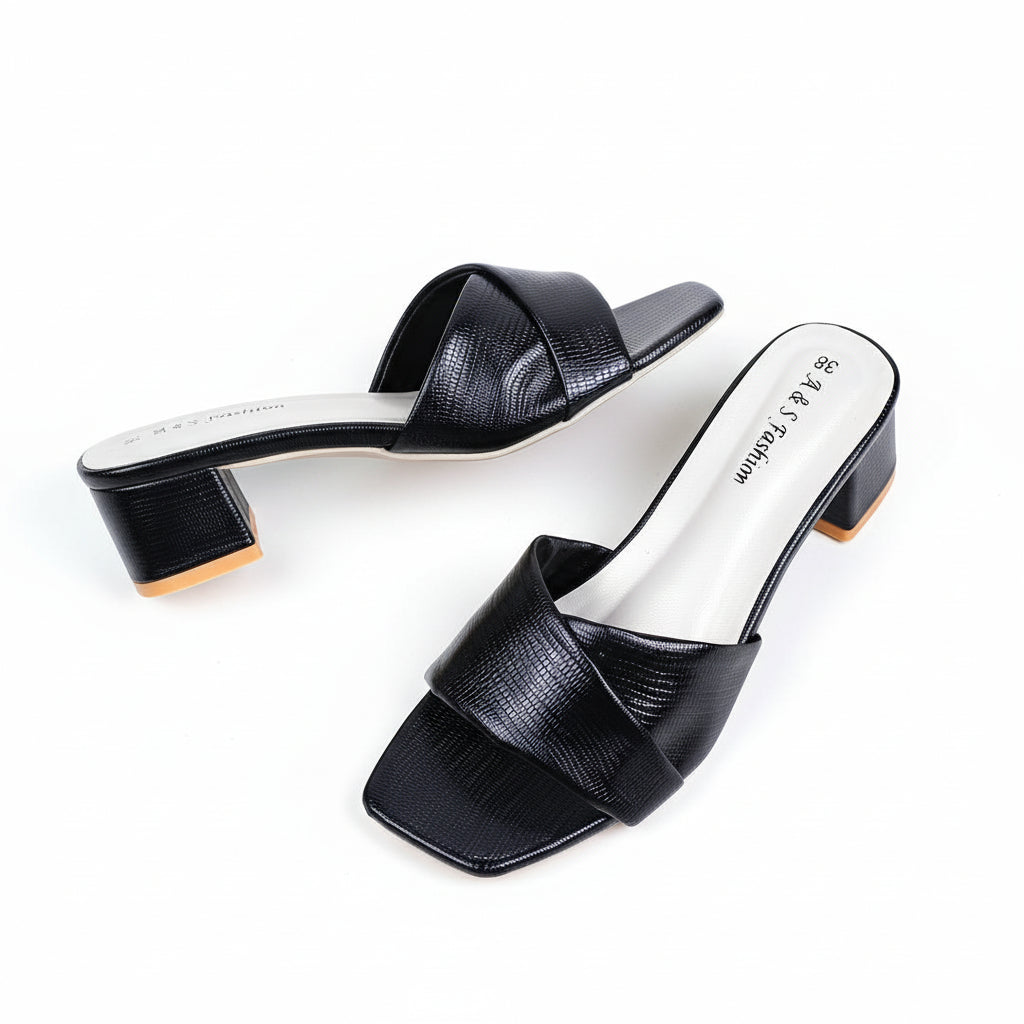 Black open-toe shoes with white soles on a beige background