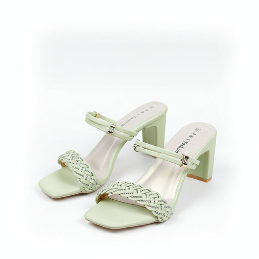 Light green high-heeled shoes with decorative straps on a white surface.